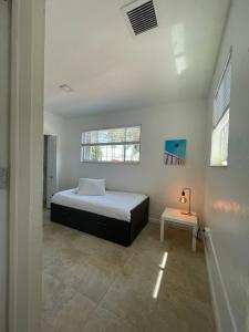 a white bedroom with a bed and a table at Best location Miami Brickell 3 bedroom Home in Miami