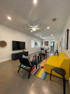 ein Wohnzimmer mit einem Sofa, Stühlen und einem TV in der Unterkunft Best location Miami Brickell 3 bedroom Home in Miami