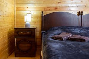 a bedroom with a bed and a nightstand with two towels at Cosy Kvara77 in Zugdidi