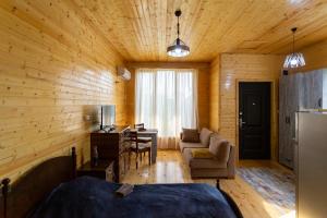 a room with a bed and a couch and a desk at Cosy Kvara77 in Zugdidi
