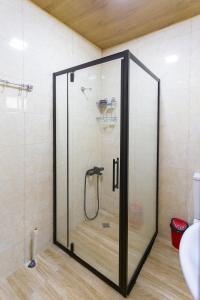 a shower with a glass door in a bathroom at Cosy Kvara77 in Zugdidi