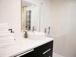 ein weißes Badezimmer mit Waschbecken und Spiegel in der Unterkunft Espacioso apartamento en el centro de Pamplona in Pamplona