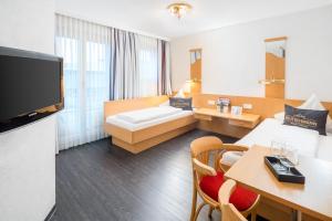 a hotel room with two beds and a television at 4-Länder-Hotel Deutschmann in Bregenz