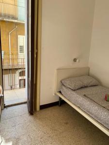 een kleine kamer met een bed en een raam bij Affitti brevi "Max FORTUNA" in Ragusa