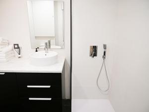 ein weißes Badezimmer mit Waschbecken und Dusche in der Unterkunft Espacioso apartamento en el centro de Pamplona in Pamplona