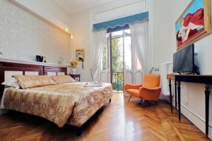 a bedroom with a bed and a television and a chair at Domus Monamì Luxury Suites in Rome