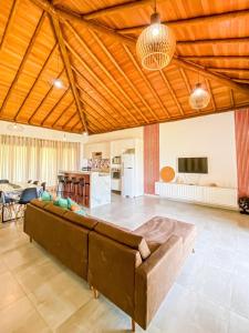 Il comprend un grand salon avec un canapé et une cuisine. dans l'établissement Casa Jardim das Bromélias, à Marau