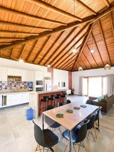 Il comprend une grande cuisine et une salle à manger avec une table et des chaises. dans l'établissement Casa Jardim das Bromélias, à Marau
