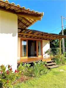 une petite maison avec une pergola en bois dans l'établissement Casa Jardim das Bromélias, à Marau