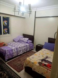 een slaapkamer met 2 bedden met paarse lakens bij سيدى بشر in Alexandrië