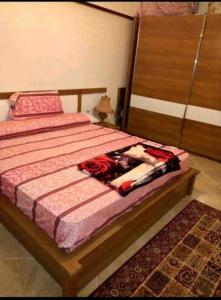 een slaapkamer met een bed met een houten hoofdeinde bij سيدى بشر in Alexandrië