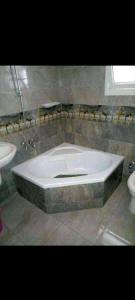 een groot bad in een badkamer met een wastafel bij سيدى بشر in Alexandrië