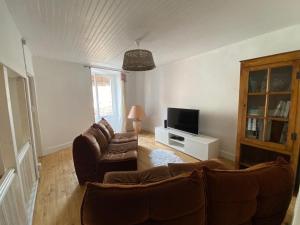 ein Wohnzimmer mit 2 Sofas und einem TV in der Unterkunft Cottage viva la vida in Auzon