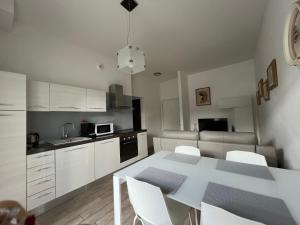a kitchen with a white table and white cabinets at Appartamento Noi Due in Riva del Garda