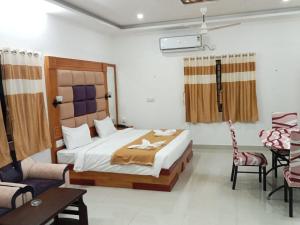 1 dormitorio con 1 cama, mesa y sillas en Aruna Residency en Sankarankovil