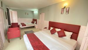 a bedroom with a large bed with red pillows at Hotel New Meadows View in Manāli