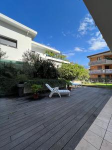 um pátio com um banco branco e um edifício em Appartamento Noi Due em Riva del Garda