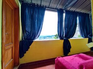 een slaapkamer met een raam met blauwe gordijnen bij La Finestra sul Corso in Bucchianico