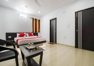 Hotel S G International Danapur في Dānāpur: غرفة نوم بسرير واريكة وطاولة