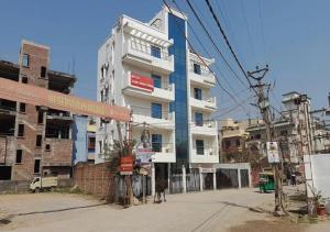 un gran edificio blanco en una calle de la ciudad en Hotel S G International Danapur, en Dānāpur