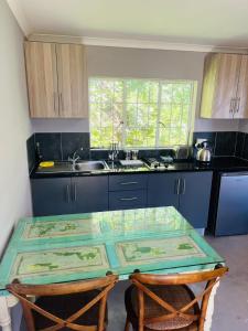 Cachai Cottage في هيلتون: مطبخ مع طاولة زجاجية ومغسلة