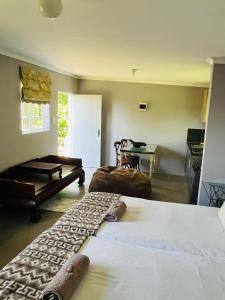 a bedroom with two beds and a table and a kitchen at Cachai Cottage in Hilton