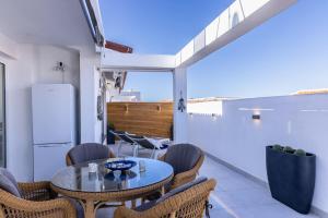 a patio with a table and chairs and a refrigerator at A Luxurious Villa On The Island Of Tenerife in Playa de San Juan