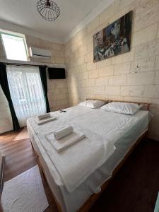 Petra Hotel & Coffee House في سانليورفا: غرفة نوم بسرير كبير عليها منشفتين