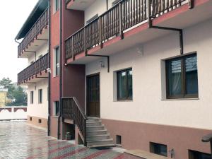 ブラショヴにあるPension Deutsches Hausのバルコニー付きの建物、階段が横にある建物