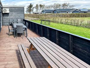 a wooden deck with a table and chairs on it at 14 person holiday home in Vinderup in Vinderup