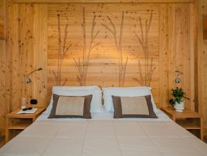 a bedroom with a large bed with wooden walls at Ovindoli Park Hotel & SPA in Ovindoli