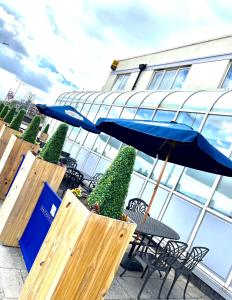 einem Tisch mit einem blauen Regenschirm und Stühlen vor einem Gebäude in der Unterkunft Grand Hotel Sunderland in Sunderland