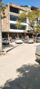 um parque de estacionamento com carros estacionados em frente a um edifício em Hotel Paradise, Patiala em Patiala