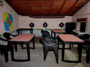 a room with four tables and chairs and a mirror at Whiterann village Homestay in Dhordo +38 photos