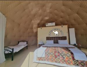 1 dormitorio con 1 cama y un cartel en la pared en White Desert Camp, en Wadi Rum