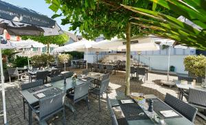 un restaurante al aire libre con mesas, sillas y sombrillas en Landgasthof Adler in 9304 Bernhardzell, en Häggenschwil