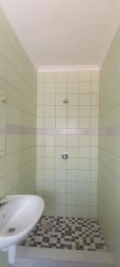 Esteem Guesthouse في Okakarara: حمام مع حوض استحمام ومغسلة