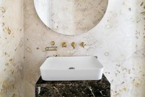 a bathroom with a white sink and a mirror at Al Samriya Hotel, Doha, Autograph Collection 