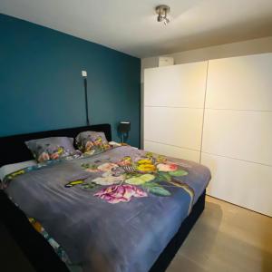 a bedroom with a bed with flowers on it at Sunny Home in Knokke-Heist