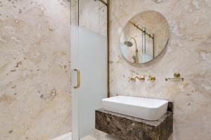 a bathroom with a sink and a mirror at Al Samriya Hotel, Doha, Autograph Collection 