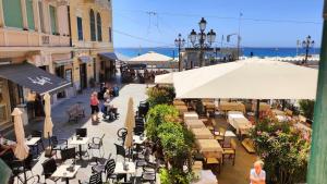 a group of tables and chairs on a street with the ocean at Appartamento centralissimo,a 20 mt dal mare in Varazze