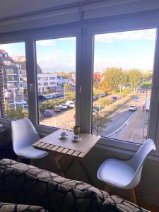 a room with a table and chairs and a large window at Sunny Home in Knokke-Heist