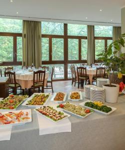 una mesa con muchos platos de comida. en Ovindoli Park Hotel & SPA, en Ovindoli