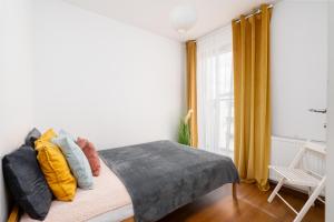 ヴロツワフにあるA.S. HOME Kościuszki Apartament dwupoziomowyのベッドルーム1室(カラフルな枕と窓付)