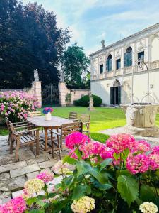 un giardino con tavolo e fiori di fronte a un edificio di Veneto Villa in Padua a Villa Osti