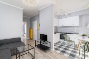 une cuisine et un salon avec un canapé et une table dans l'établissement A.S. HOME Kosciuszki, à Wrocław