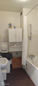 a bathroom with a sink and a tub and a shower curtain at appartement T1bis St Lary soulan village in Saint-Lary-Soulan
