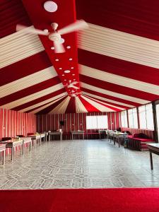 a large room with a red and white striped ceiling at Hashem desert camp in Wadi Rum