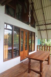 einen Holztisch auf der Veranda eines Hauses in der Unterkunft Green Cloud Villa in Ella
