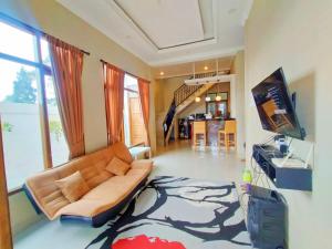 Villa Cisarua Zeni 1 في Brujul: غرفة معيشة بها أريكة وتلفزيون